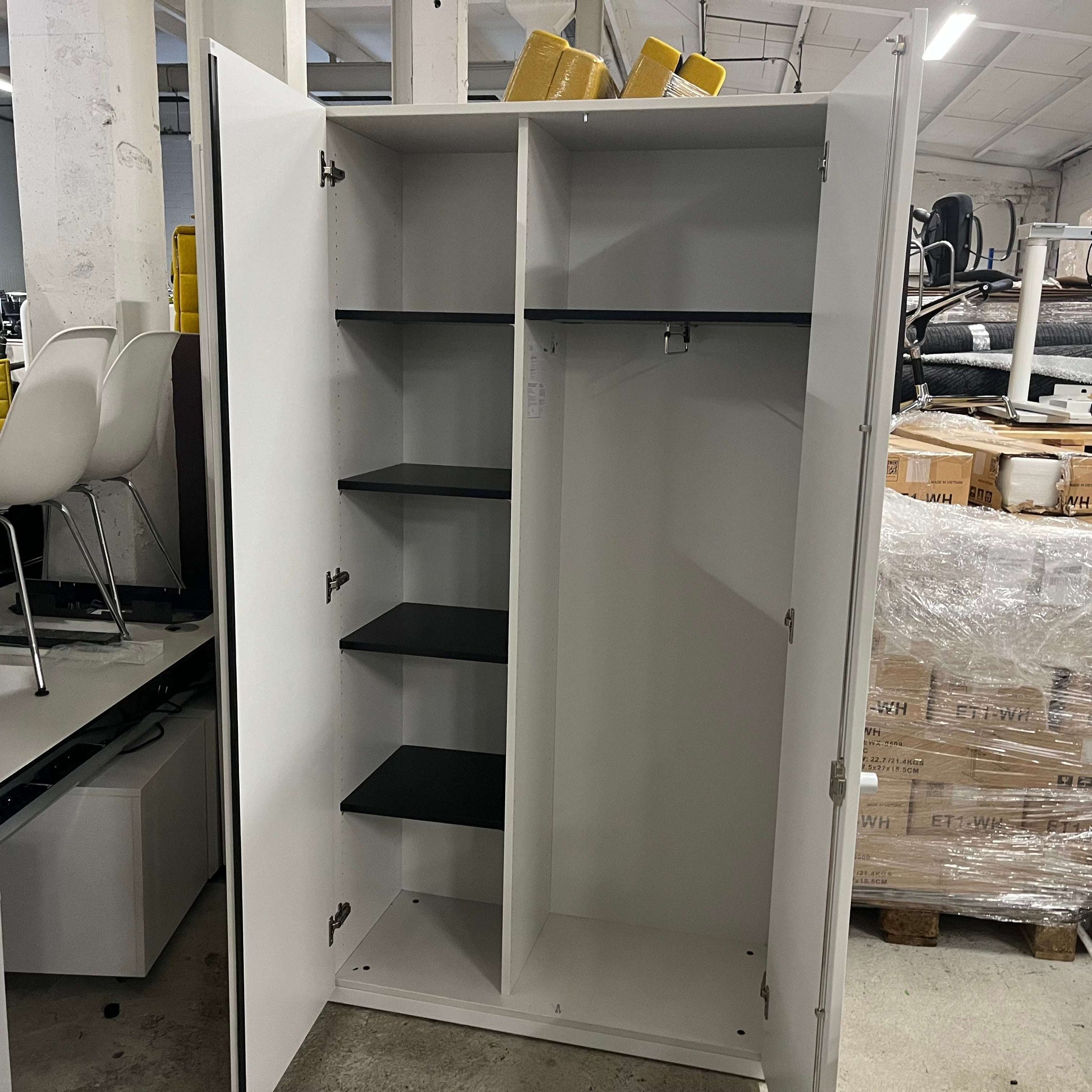 Steelcase Schrank gray wardrobe cabinet with black shelves and hanging rail open doors in storage room