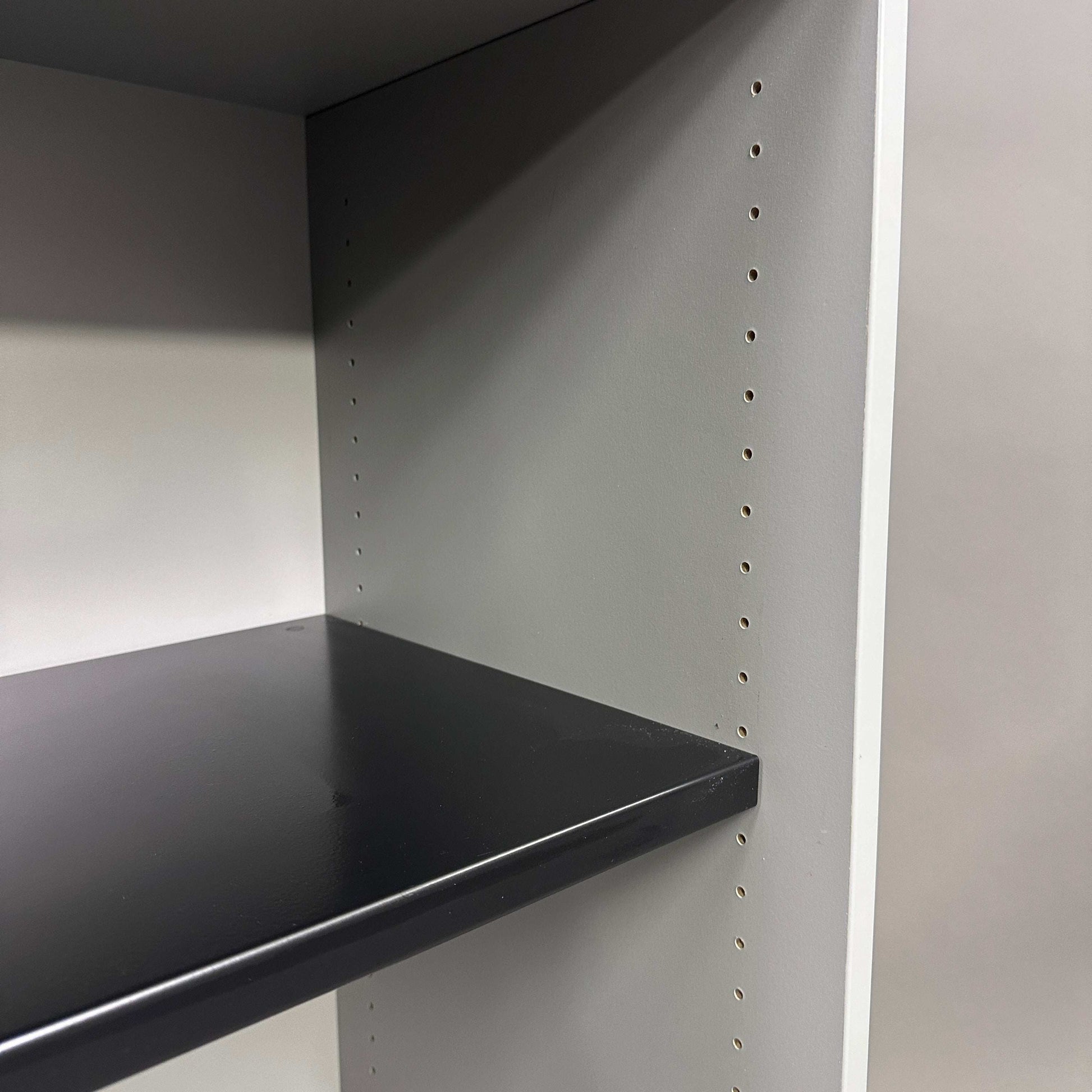 Innenansicht des lichtgrauen Steelcase Sideboards mit Metall-Einlageboden und Anpassungslöchern