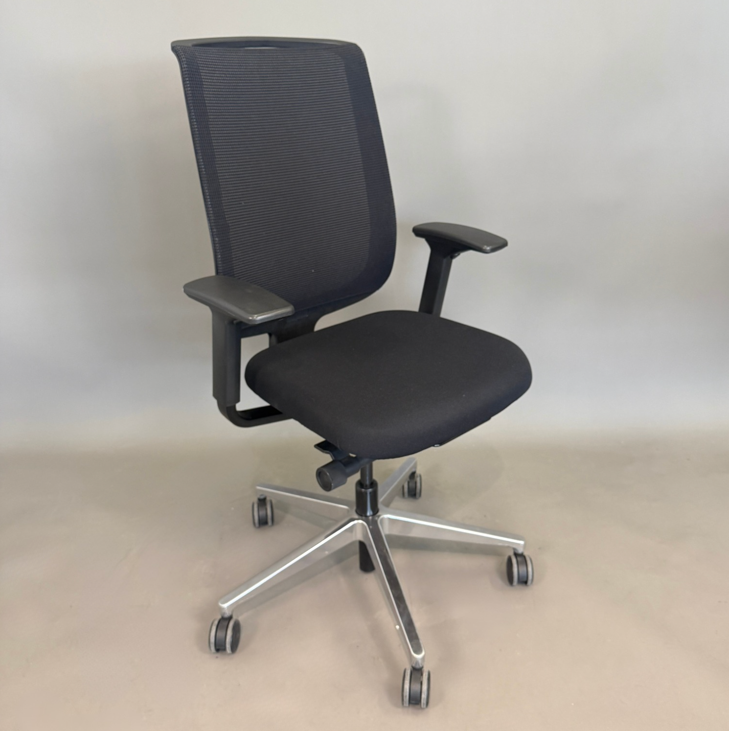 Schwarzer Steelcase Reply Bürostuhl mit Mesh-Rückenlehne, Stoffbezug und verchromtem Fußkreuz, höhenverstellbar und ergonomisch.