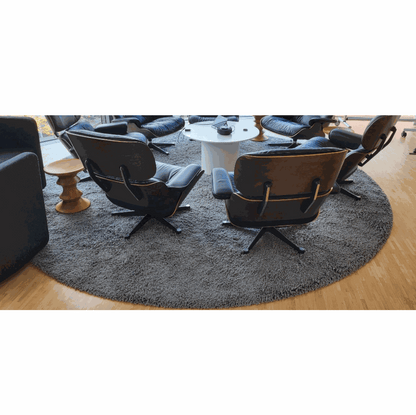 Round anthracite Object Carpet RugX in office setting with modern chairs on wooden floor