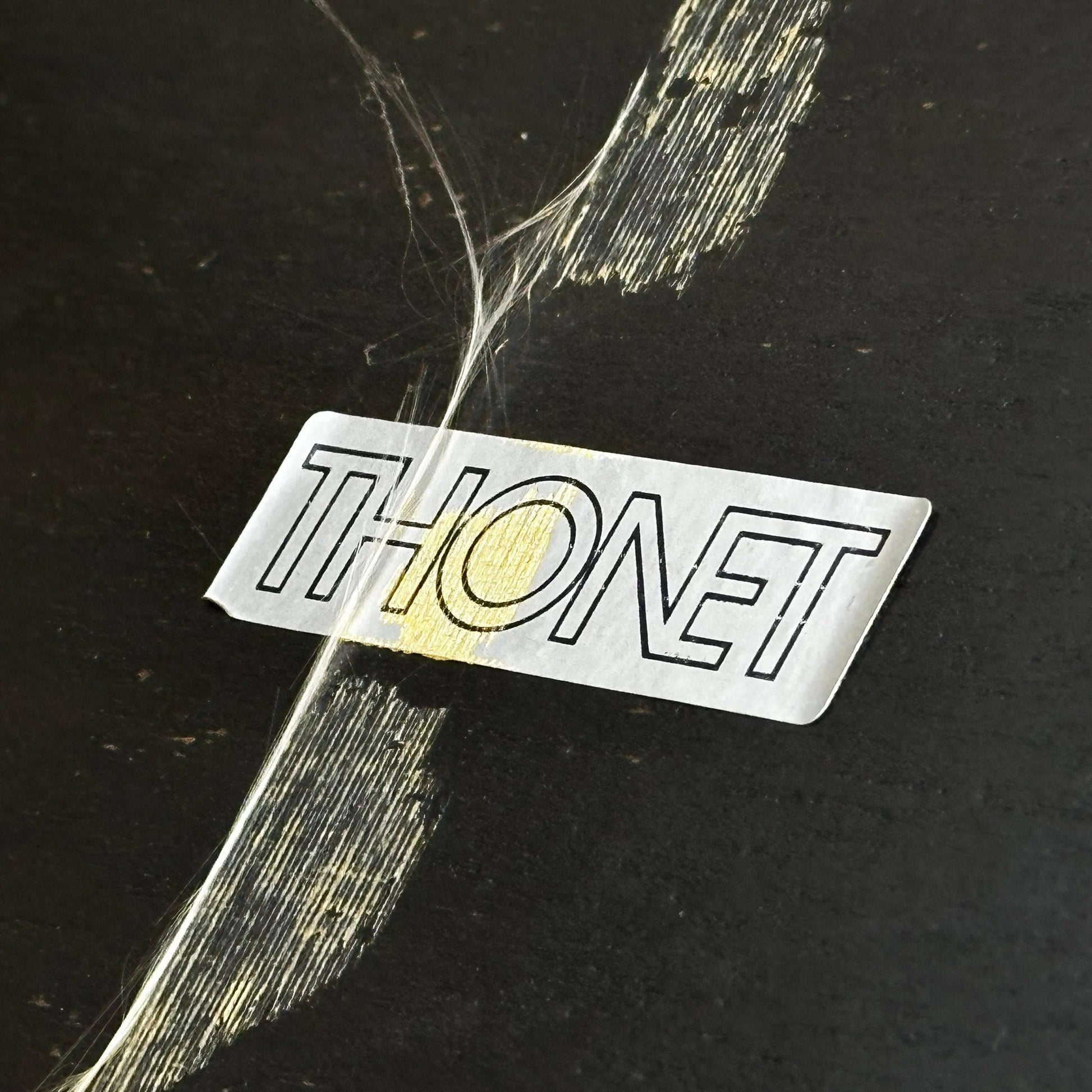 Close-up of Thonet Beistelltisch label on black and silver side table surface