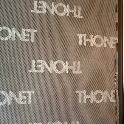 Thonet S 411 Freischwinger Sessel mit schwarzem Lederpolster und Thonet-Logo-Muster.