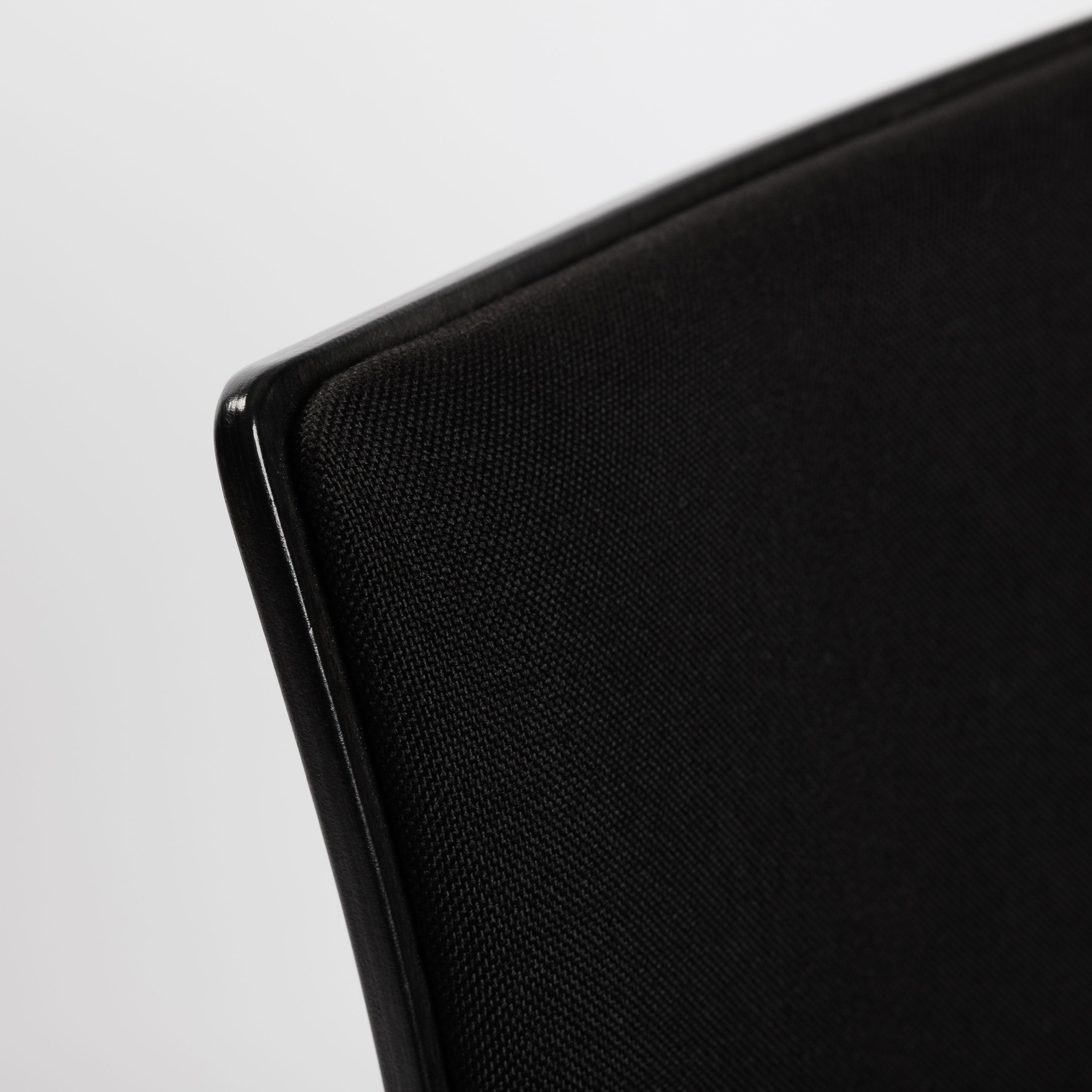 Detailaufnahme des schwarzen Thonet S166 PF Stuhls mit Stoffpolsterung und glänzender Holzkante.