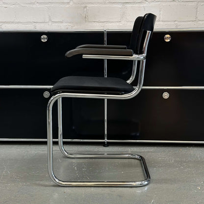 Thonet S43 PVF black chair with chrome frame, wooden armrests, and fabric upholstery, side view