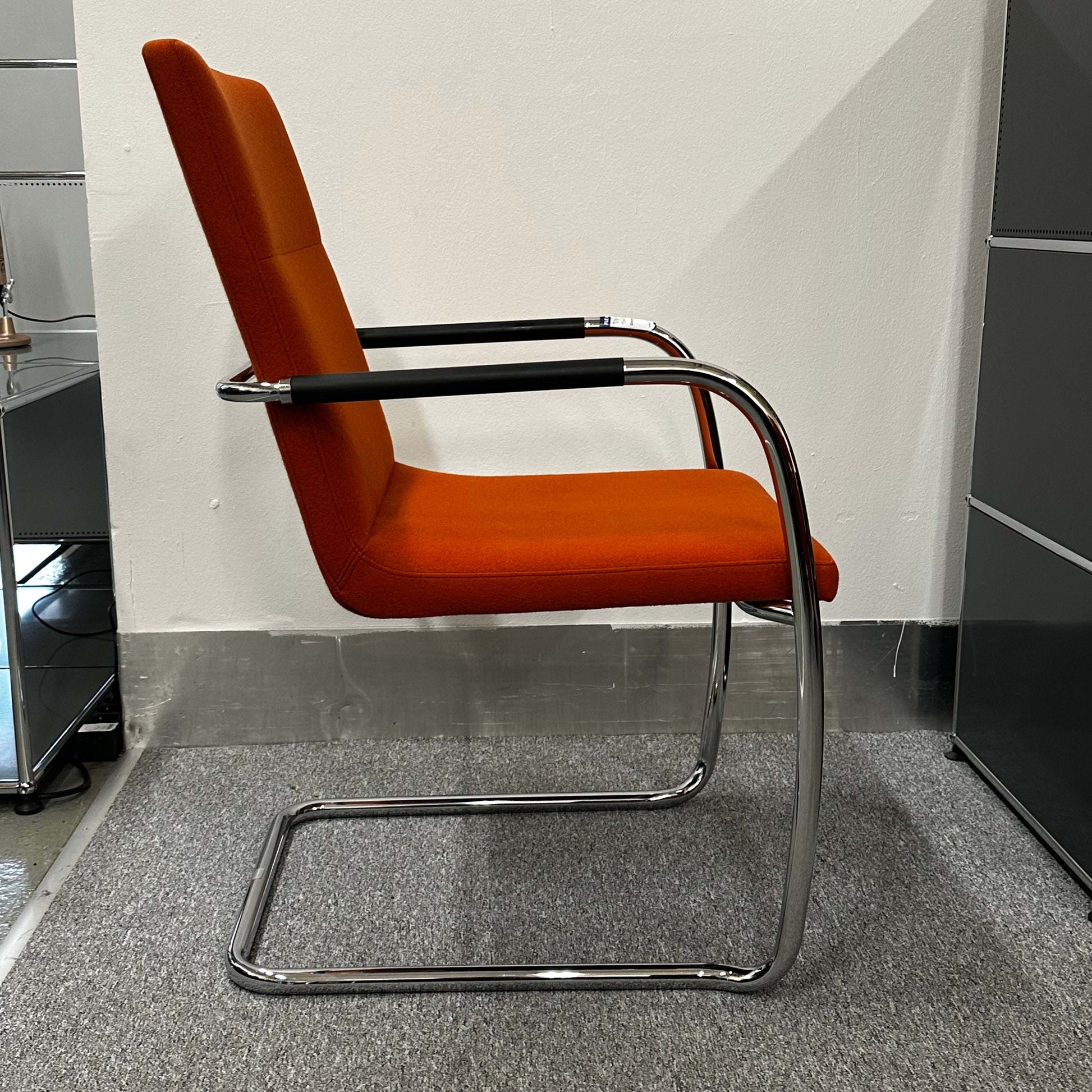 Thonet S60 chair with chrome frame and deep orange upholstery, stackable design