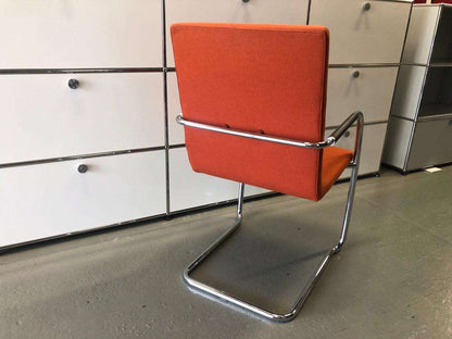Thonet S60 chair with chrome frame and deep orange upholstery, stackable design.