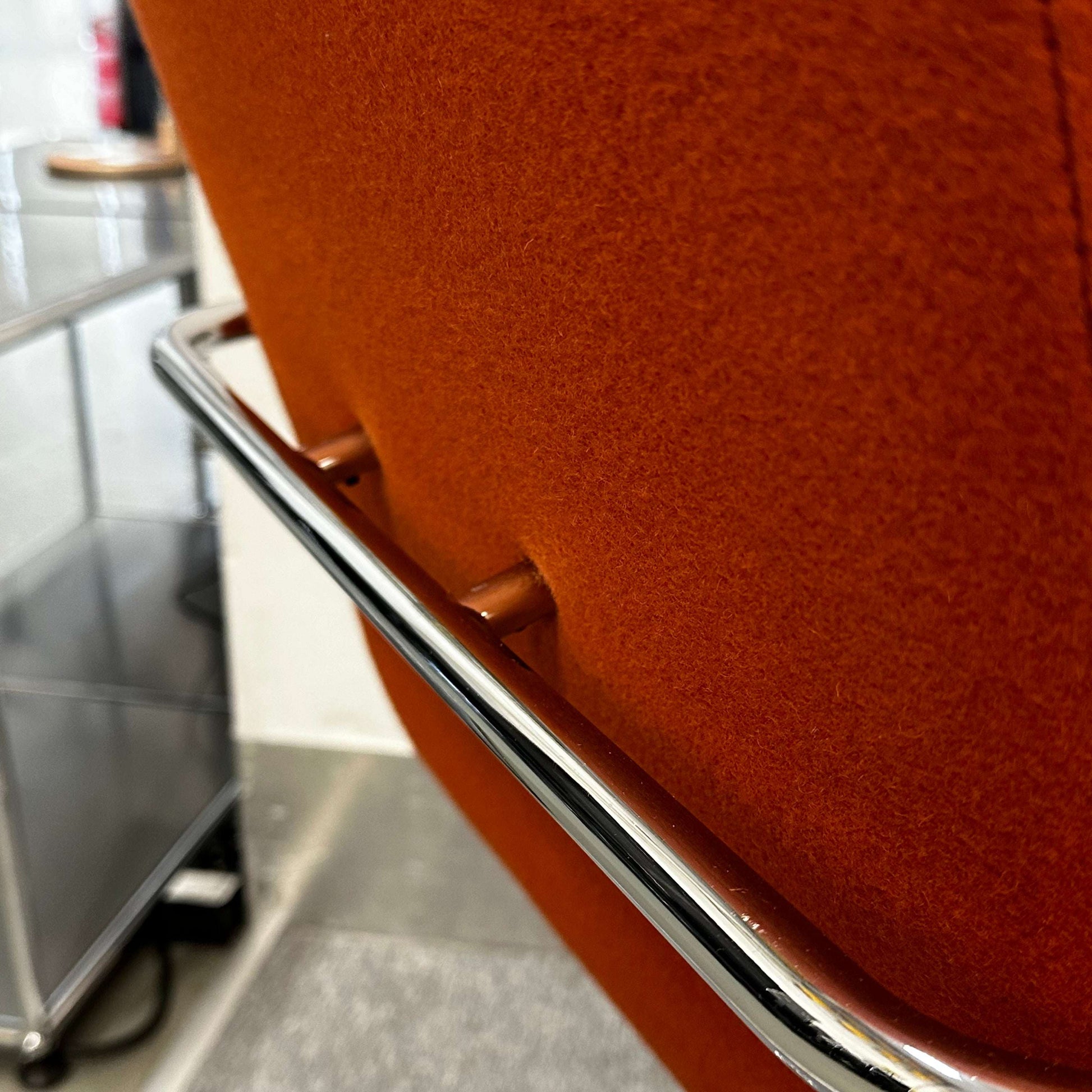 Thonet S60 chair with chrome frame and deep orange fabric, stackable design