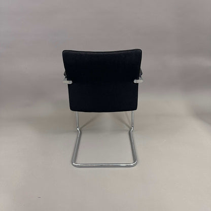 Thonet S78/S79 cantilever chair with black upholstery, matte black wooden armrests, and chrome frame viewed from the back