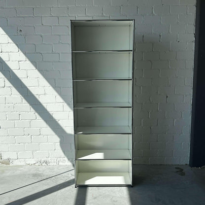 USM Haller offenes weißes 1x6 Highboard Regal vor weißer Backsteinwand mit Sonnenschein