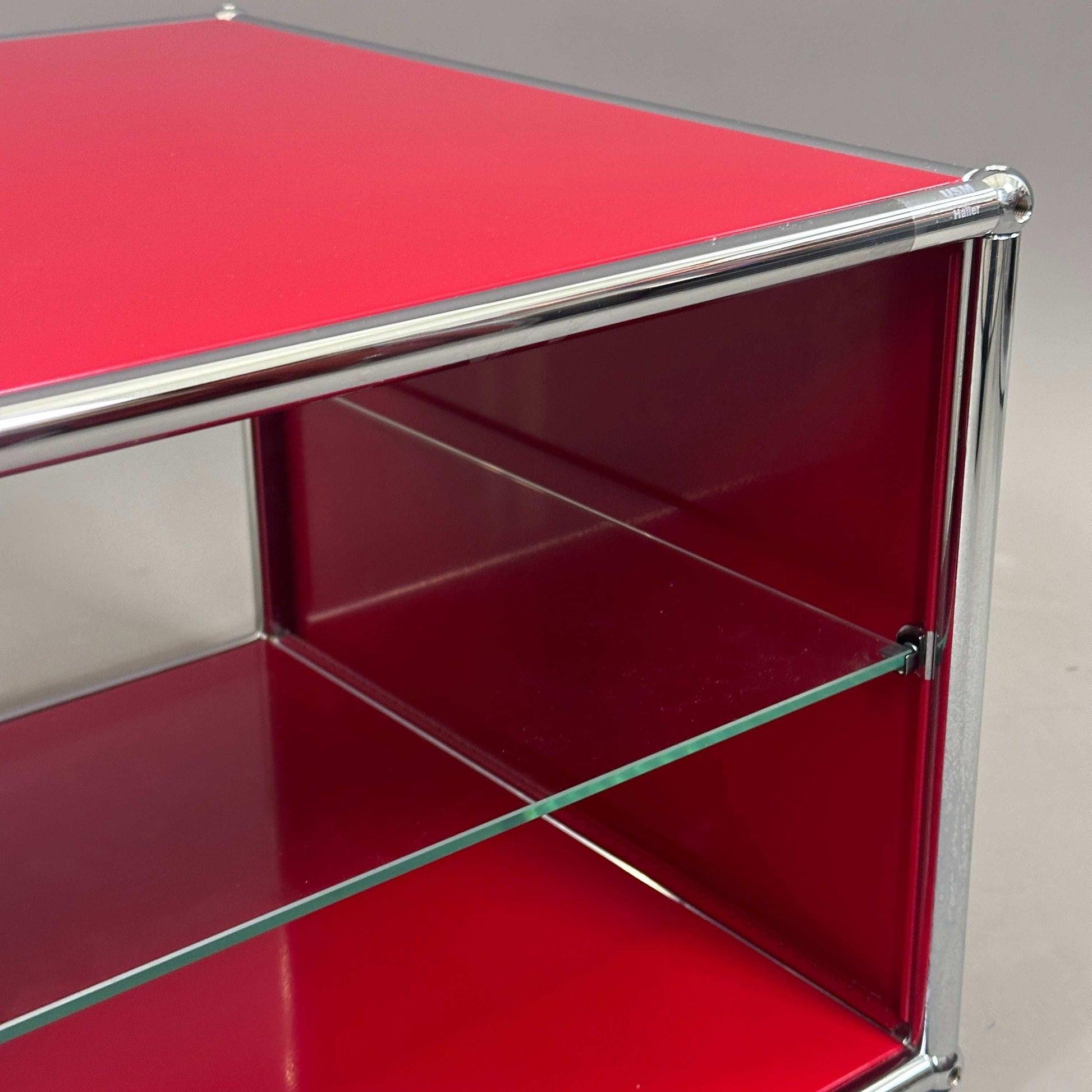USM Haller Beistelltisch in Rubinrot mit Glastablar und Metallrahmen in modernem Design