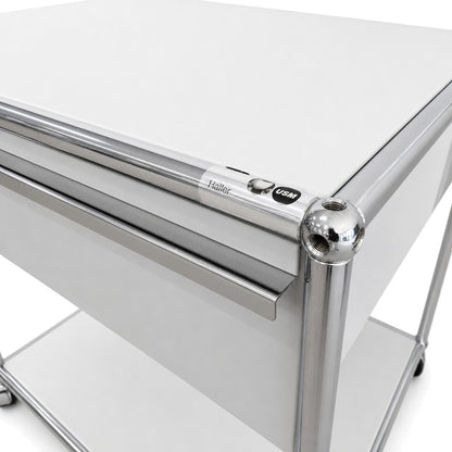 USM Haller Druckertisch in Lichtgrau mit verchromtem Stahlrohrrahmen und zwei Auszügen im klassischen Design.