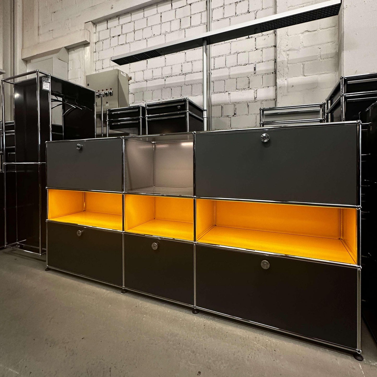 USM Haller E Highboard 3x3 anthrazit mit goldgelben beleuchteten Fächern und integrierter stromführender Struktur