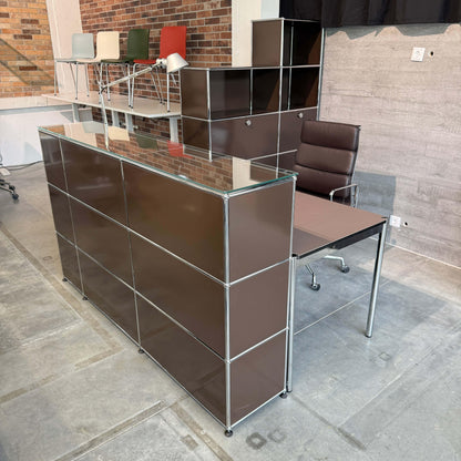 USM Haller Empfangstheke in Braun mit Glasauflage, integrierter Beleuchtung und Tisch mit Linoleum mauve und Kabelmanagement