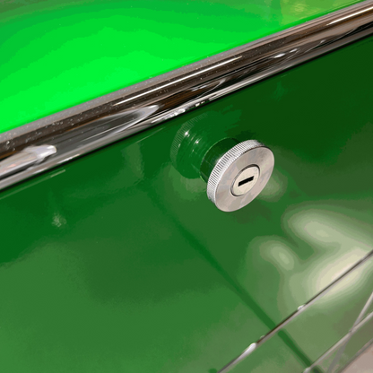 Close-up of a green USM Haller Highboard with chrome lock and soft-close flap detail