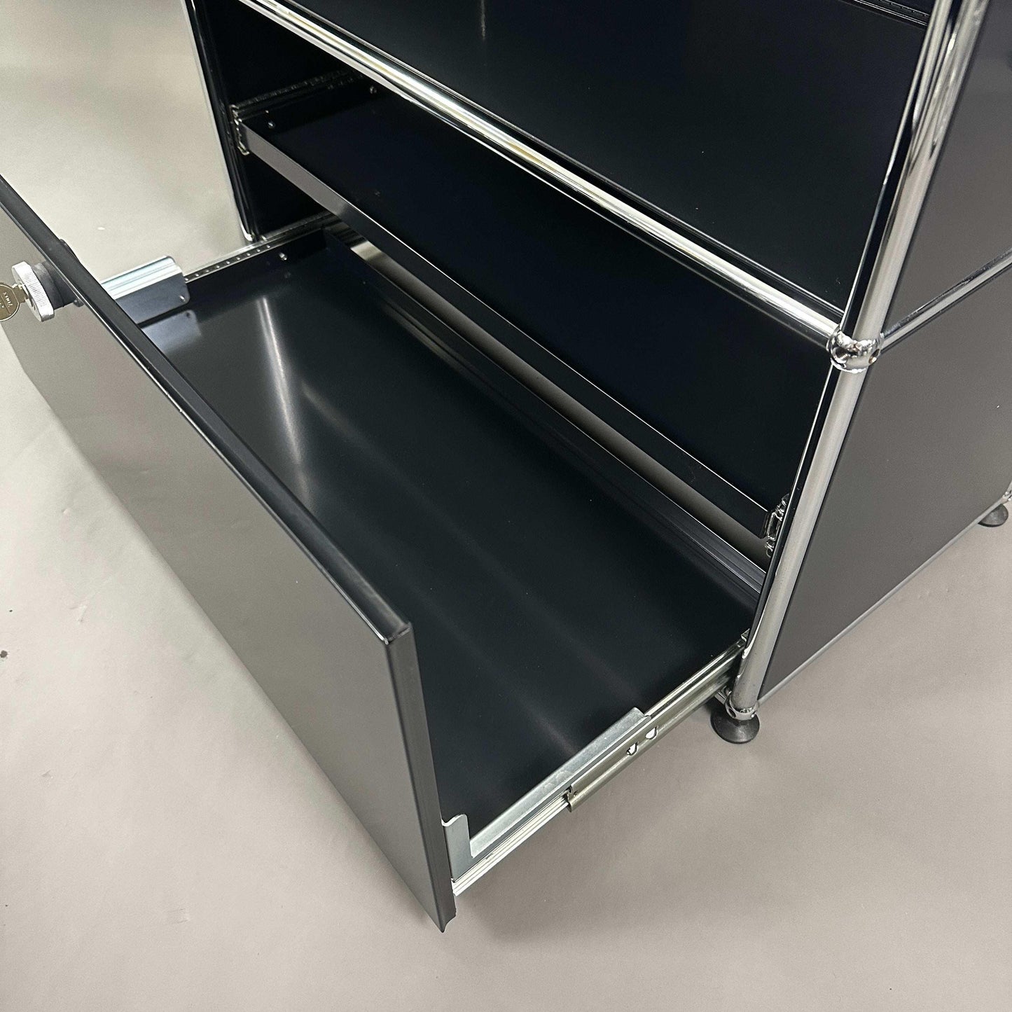 USM Haller Highboard in graphitschwarz mit einem offenen Auszug und drei Fächern aus Metall