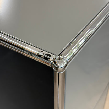 USM Haller Highboard in mittelgrau mit verchromten Stahlrohren und Kugelverbindern, Detailansicht.