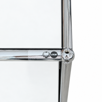 Detailansicht eines USM Haller Highboards in Reinweiß mit verchromtem Stahlrohrrahmen und charakteristischem Kugelgelenk.