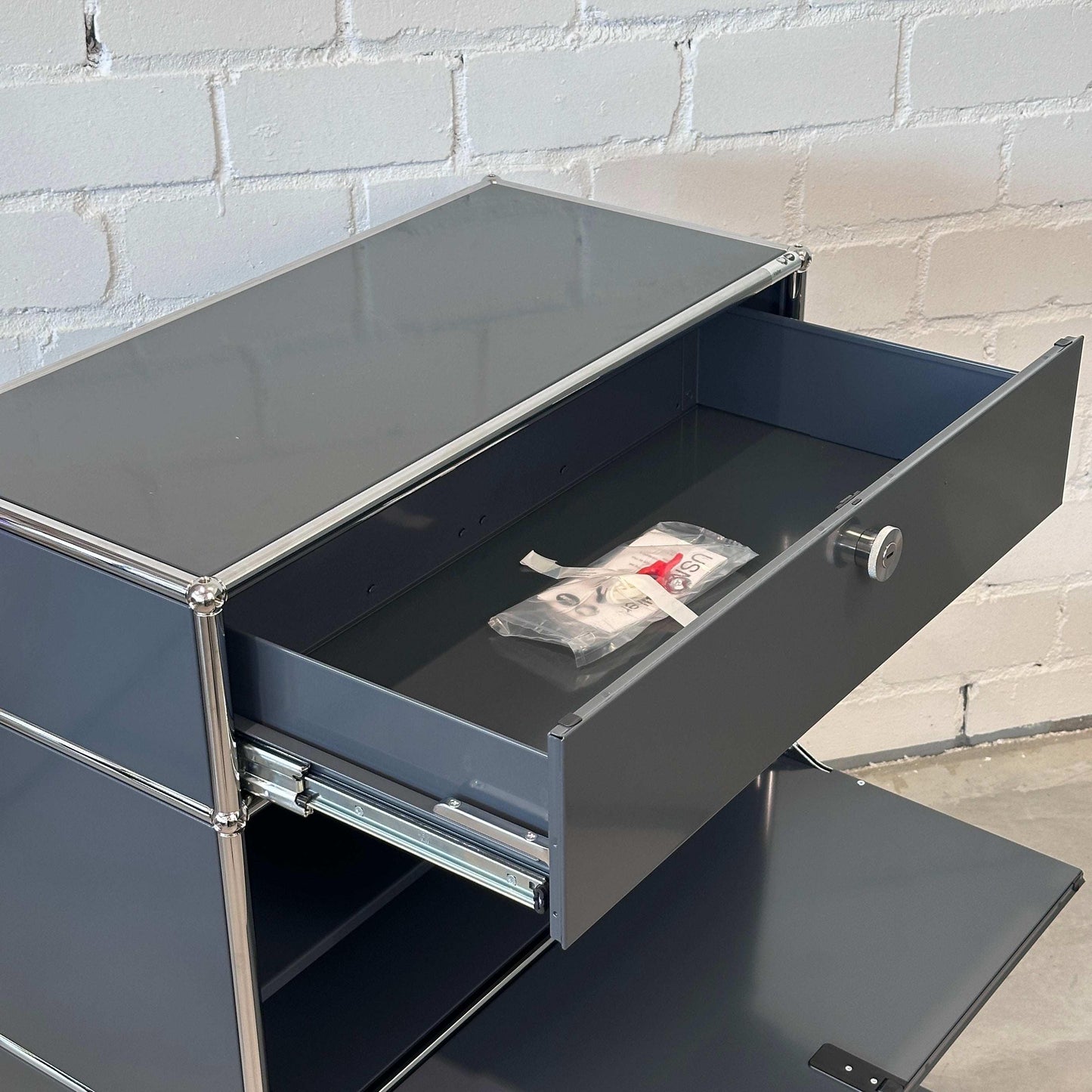 USM Haller Highboard 1x3 anthrazit mit geöffneter Schublade und Klappe, modernes Softclose Design