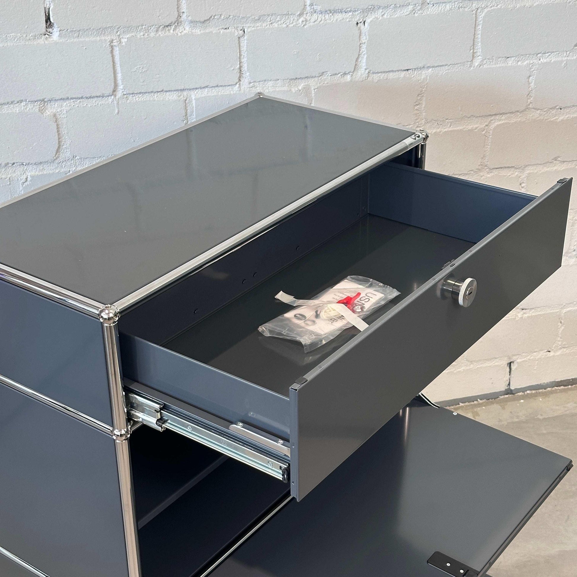 USM Haller Highboard 1x3 anthrazit mit geöffneter Schublade und Klappe, modernes Softclose Design