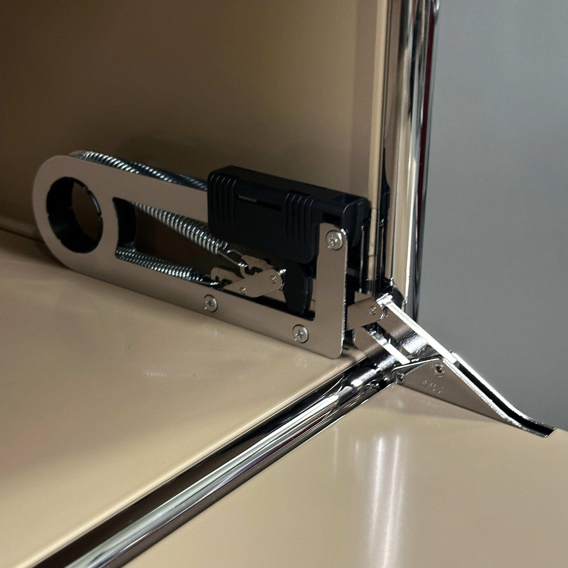 Nahaufnahme des Scharniers eines beigen USM Haller Highboard 1x3 mit Klappen, Detail der Metallverbindung und Oberfläche.