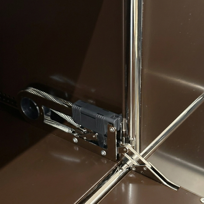 USM Haller Highboard Detail: braunes Metallmodul mit verchromtem Gestell und Klappenmechanismus.