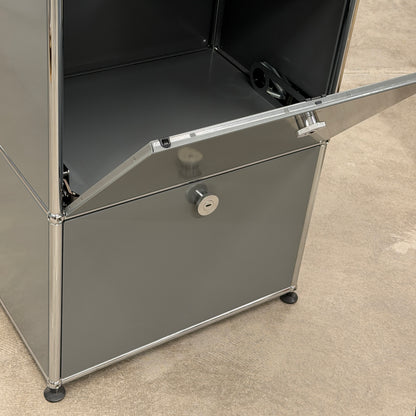 USM Haller Highboard 1x3 in mittelgrau mit zwei offenen Klappen und Chromgestell.