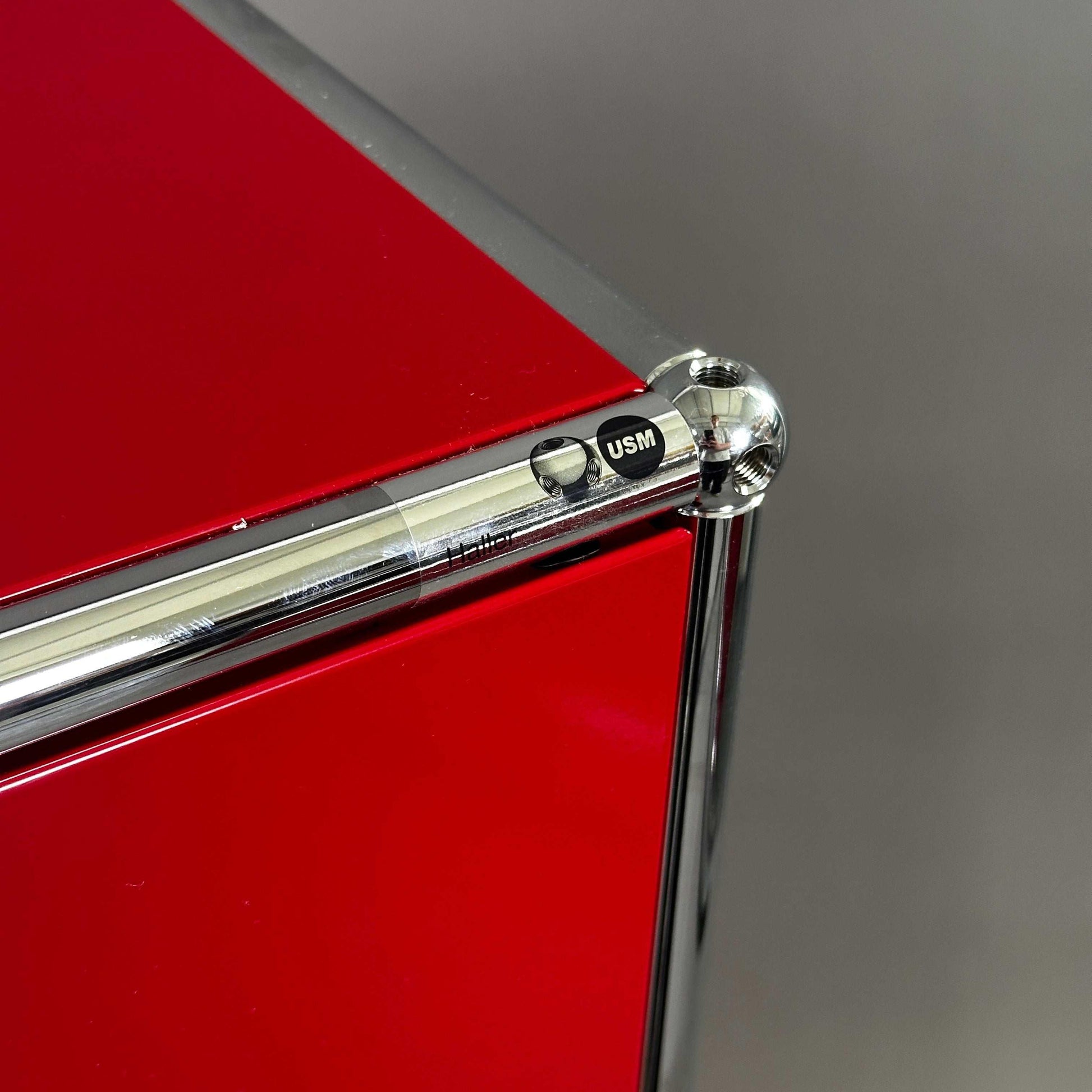 USM Haller rotes Highboard 1x3 mit glänzenden Metallklappen und Chromrahmen, Nahaufnahme Ecke