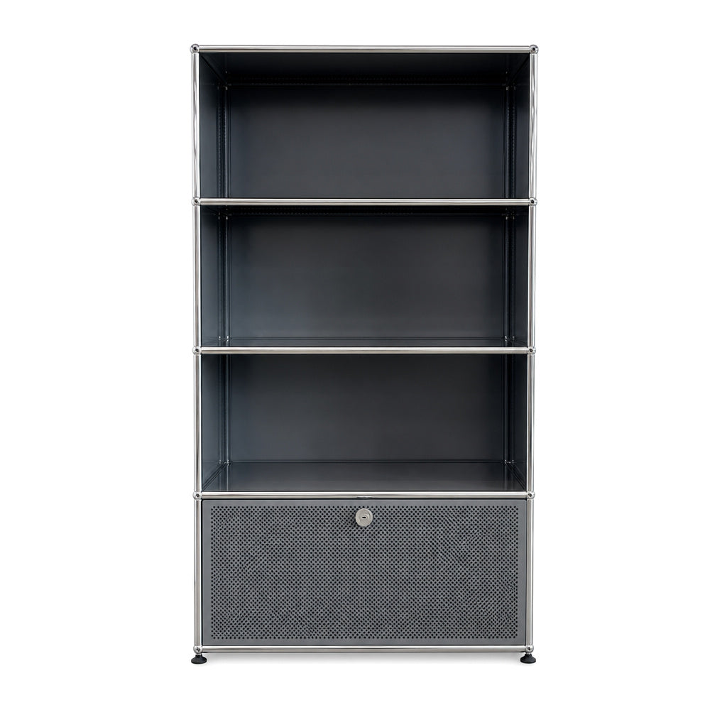 USM Haller Highboard in Mittelgrau mit drei offenen Fächern und einem abschließbaren, perforierten Auszug.