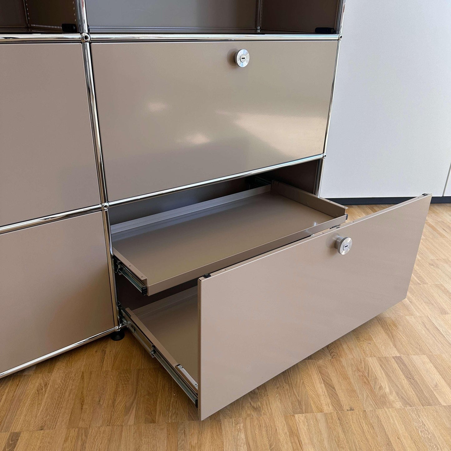 USM Haller Highboard 2x3 beige mit geöffneten Auszügen auf Holzfußboden