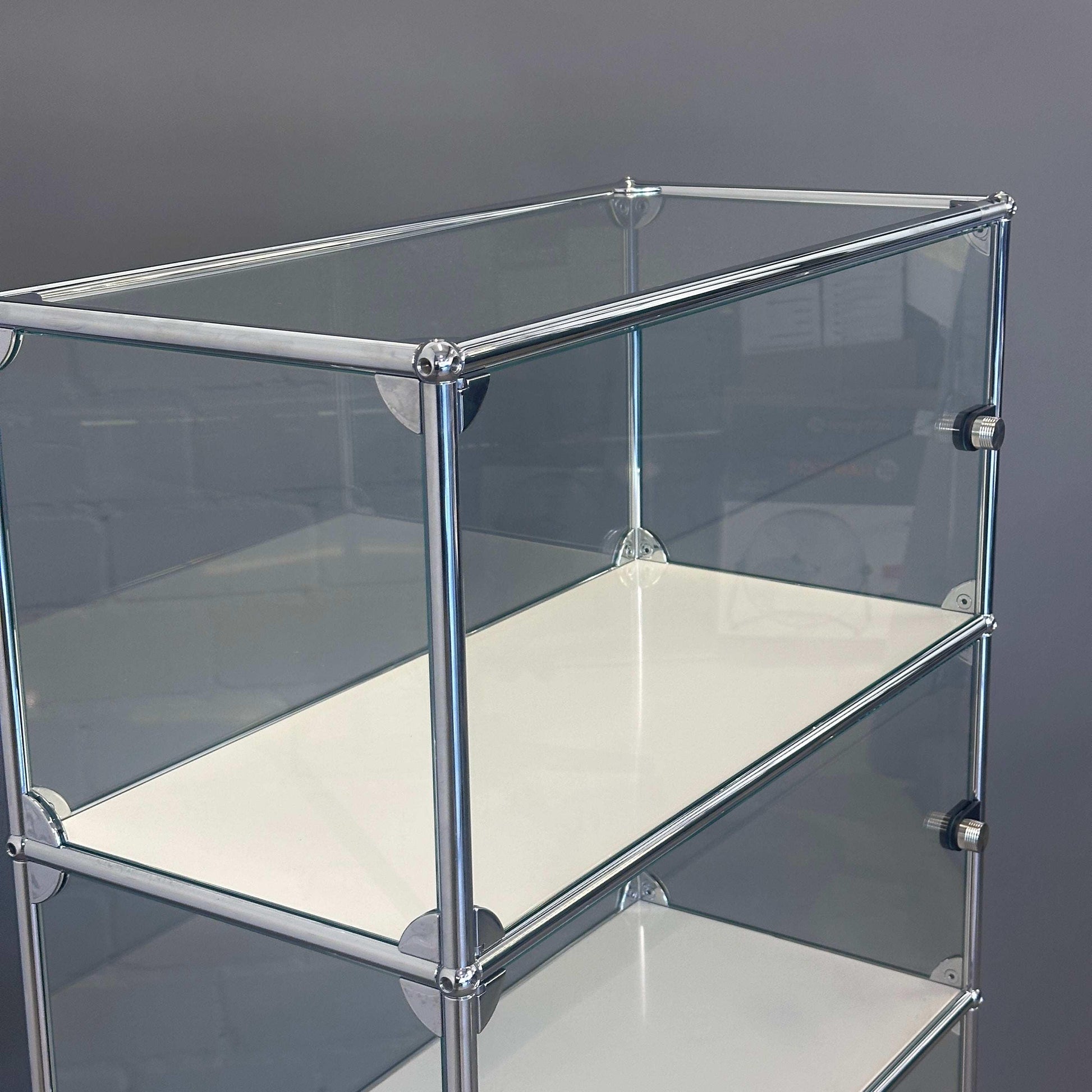 USM Haller Highboard Vitrine aus Glas mit weißen Fachböden und chromfarbenem Rahmen