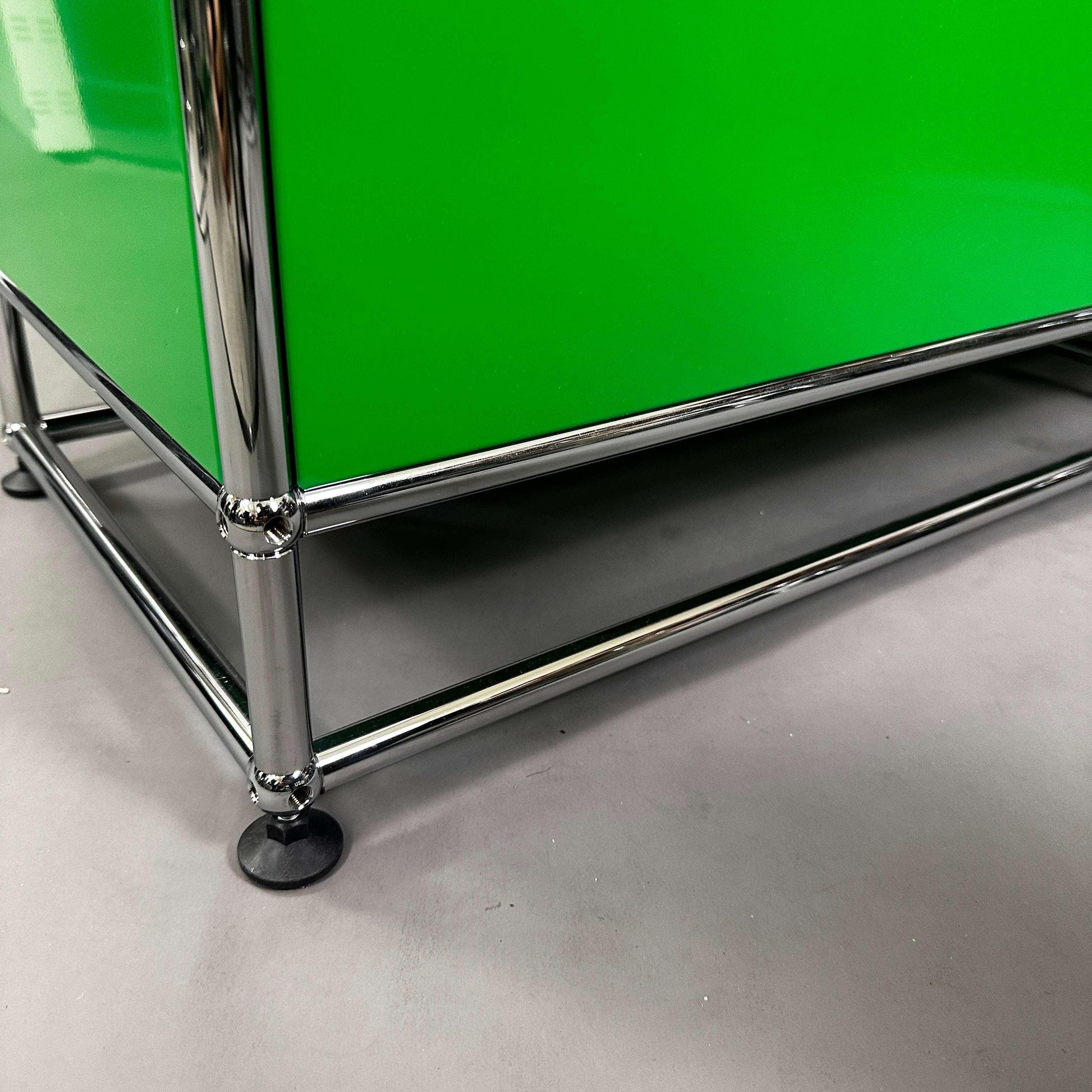 USM Haller Highboard Detailaufnahme grün-gelb-schwarzes Design mit Chromrahmen und Standfüßen