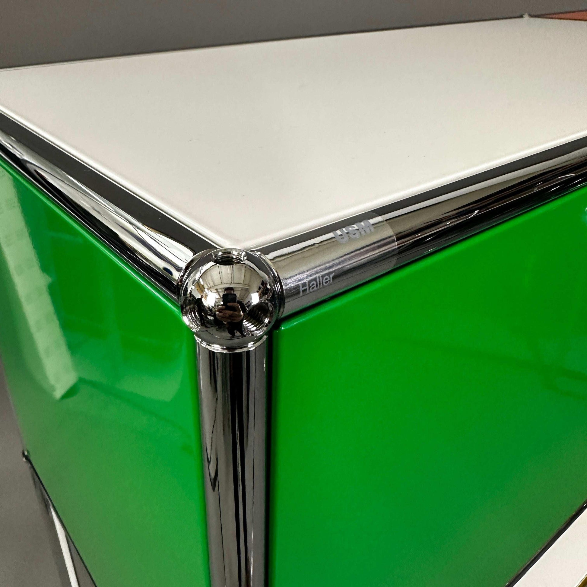 USM Haller Highboard mit grünem Klappfach und chromfarbenen Eckverbindungen