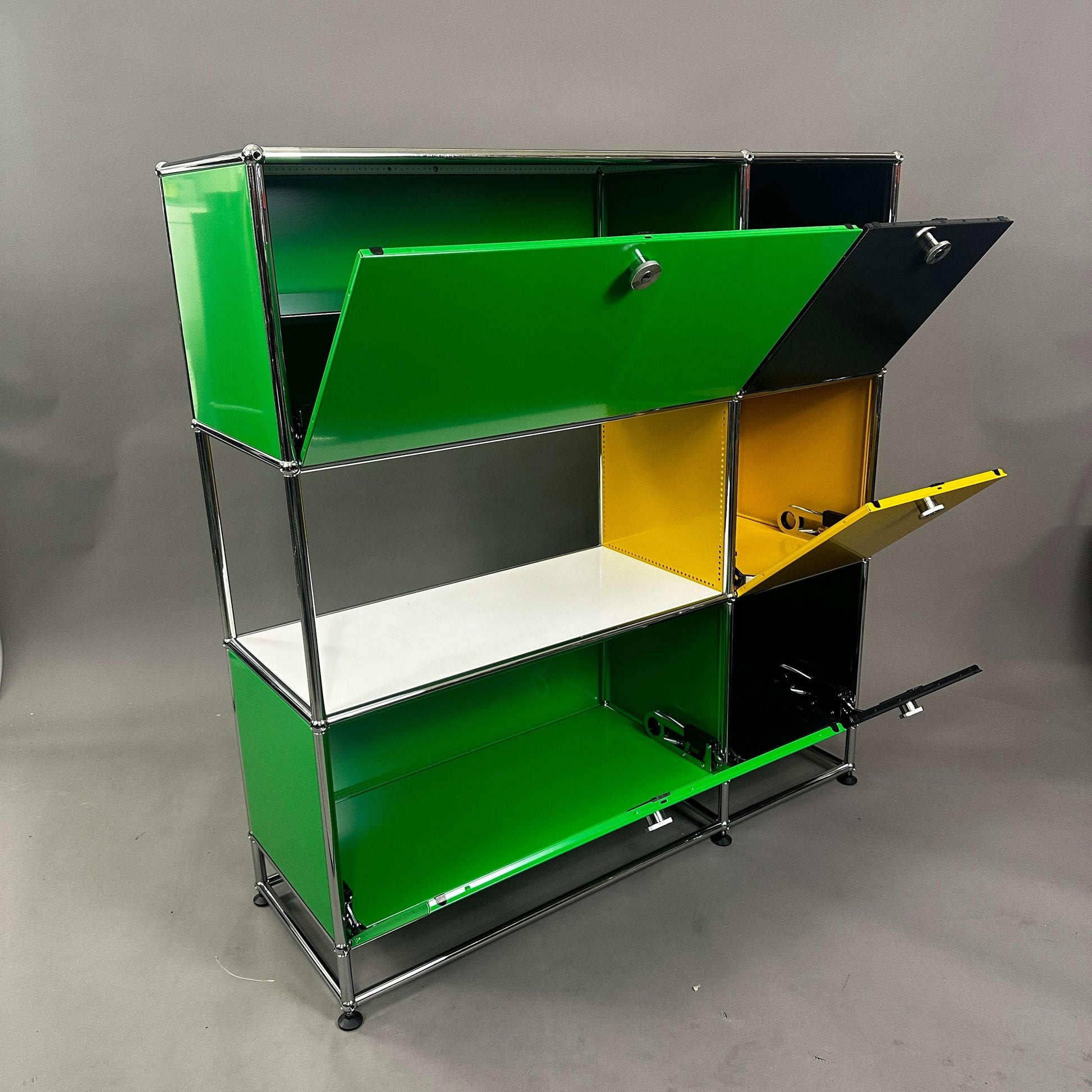 USM Haller Highboard mit grünen, gelben und schwarzen Klappen und weißem Zwischentablar, 120x112x38 cm
