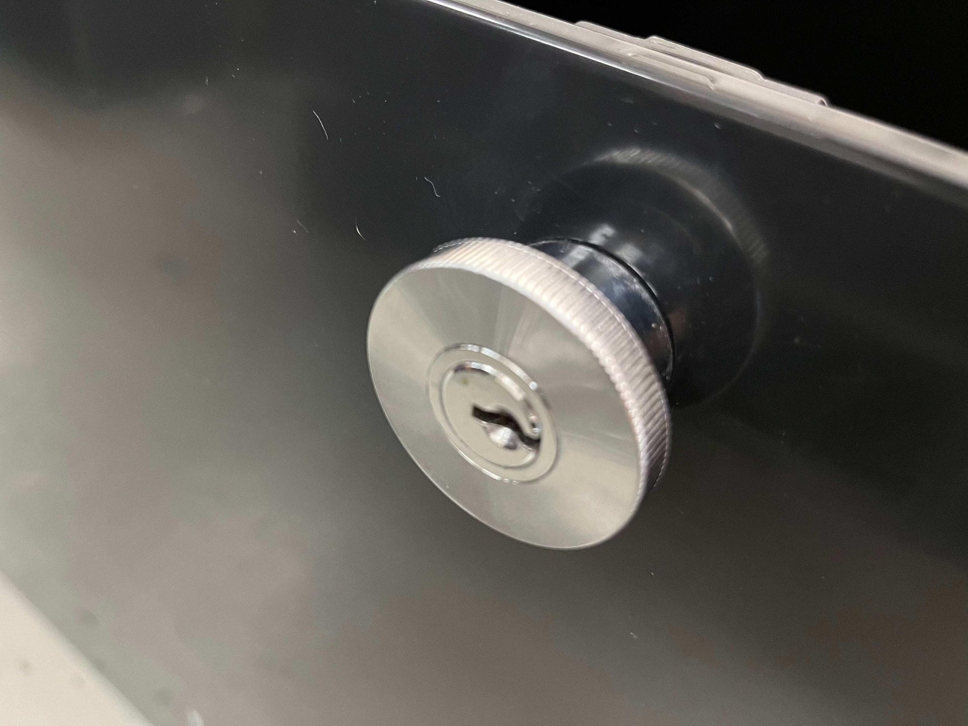 Close-up of the locking knob on the black USM Haller Highboard drawer