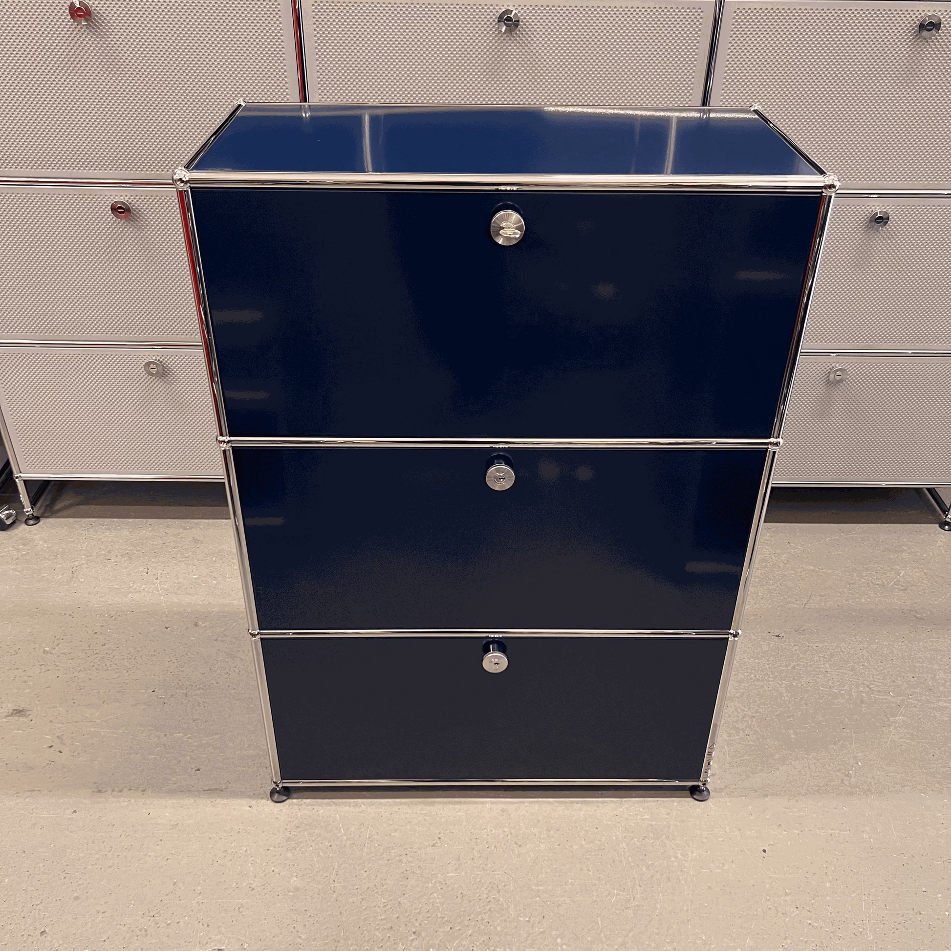 USM Haller highboard in steel blue with three flap compartments and chrome frame, dimensions 109x78x38 cm.