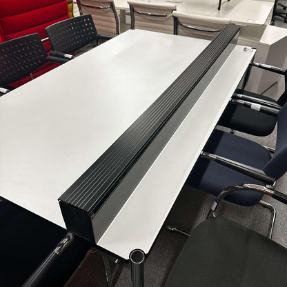 USM Haller Kabelkanal mounted on the side of a white office table organizing cables
