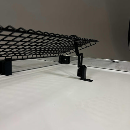 Black foldable USM Haller cable basket mounted under a desk for cable management with included fastening accessories