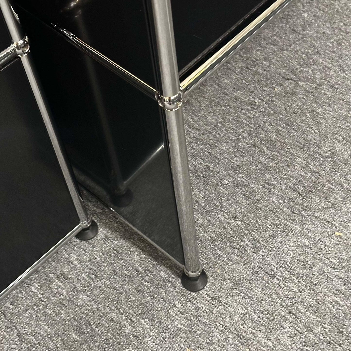 USM Haller Pult highboard in graphit black with metal frame on gray carpet floor