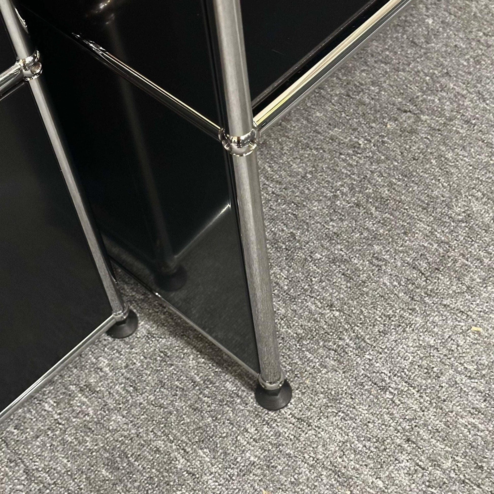 USM Haller Pult highboard in graphit black with metal frame on gray carpet floor