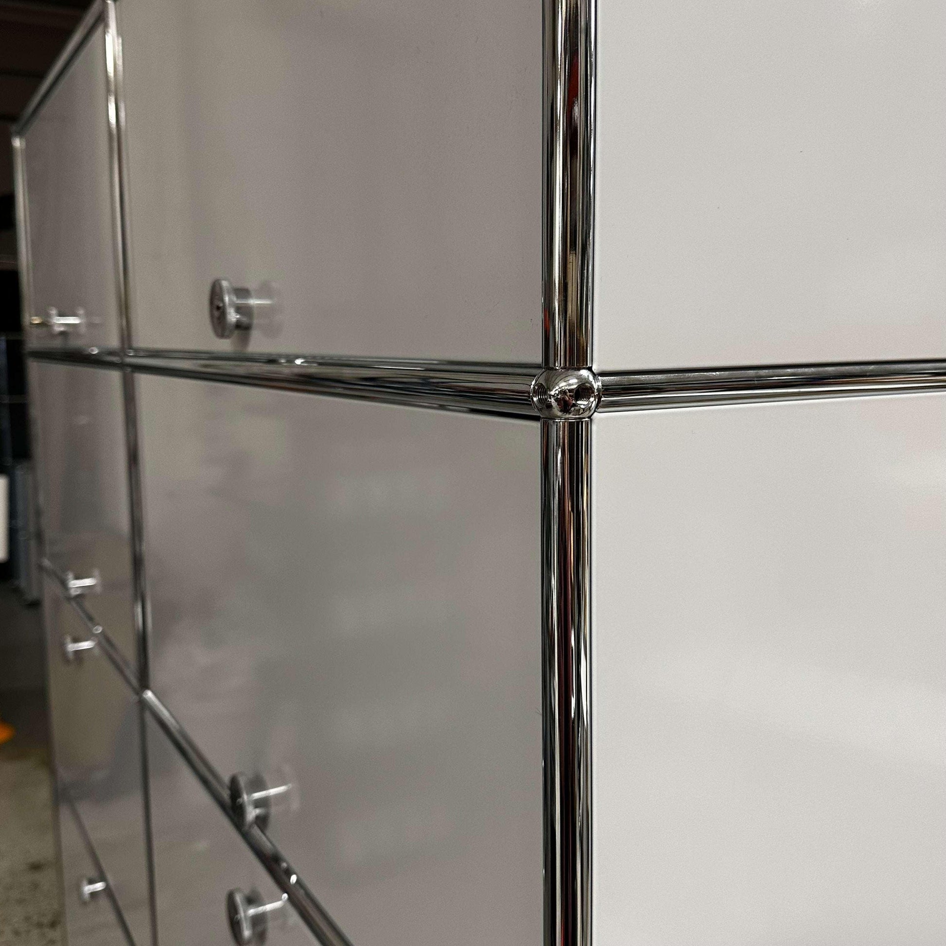 Close-up of the USM Haller Regal light gray steel cabinet with chrome frame and handles
