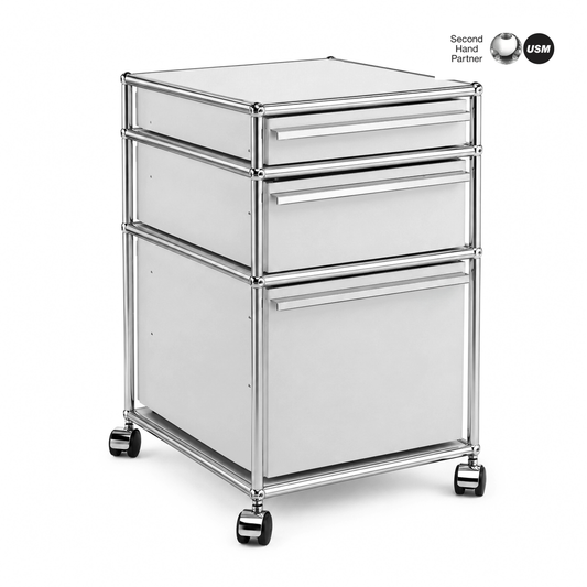 USM Haller Rollcontainer mit 3 lichtgrauen Schubladen, Chromgestell und Rollen.