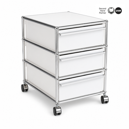 USM Haller Rollcontainer reinweiß mit 3 Schubladen, Chromgestell und Rollen.