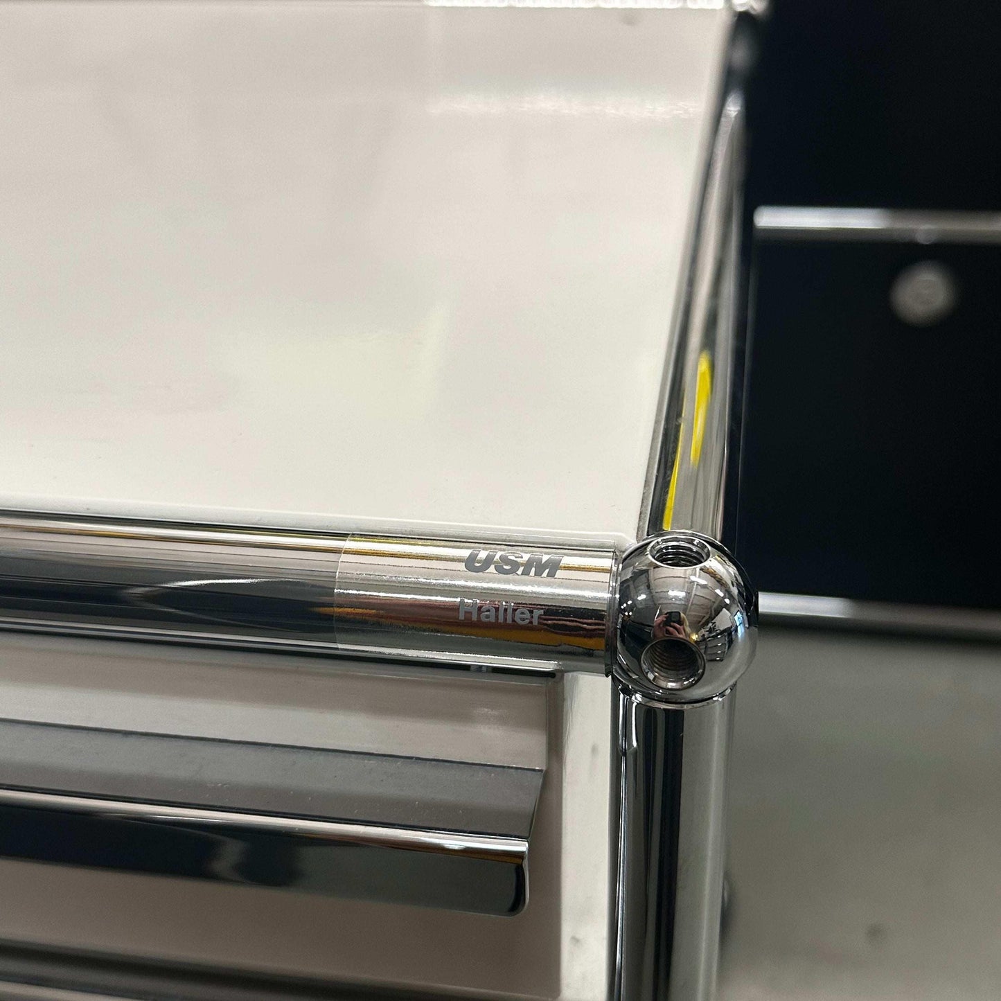USM Haller Rollcontainer close-up of chrome corner joint and white panel in Reinweiß color