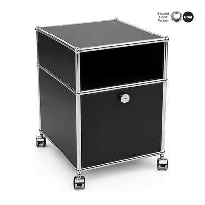 USM Haller Rollcontainer in Schwarz mit Klapptür, Kabelauslass und Rollen.