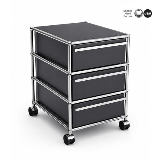 USM Haller Rollcontainer anthrazit mit 3 Schubladen, Chromgestell und Rollen.