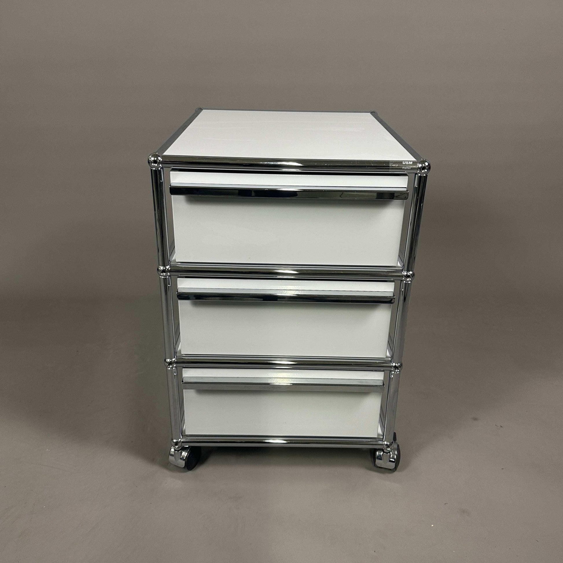 USM Haller light gray roll container with three drawers and chrome frame on casters