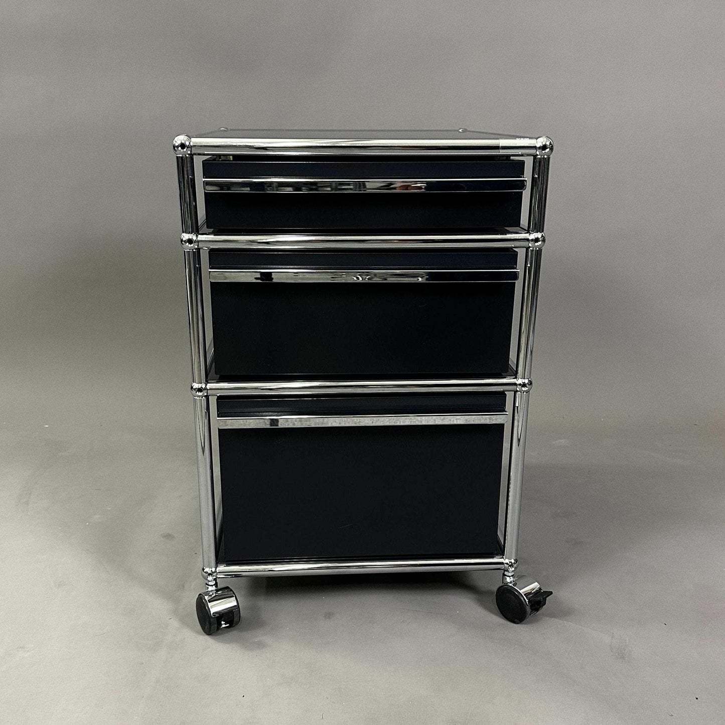 USM Haller Rollcontainer in black with three drawers and chrome frame on wheels