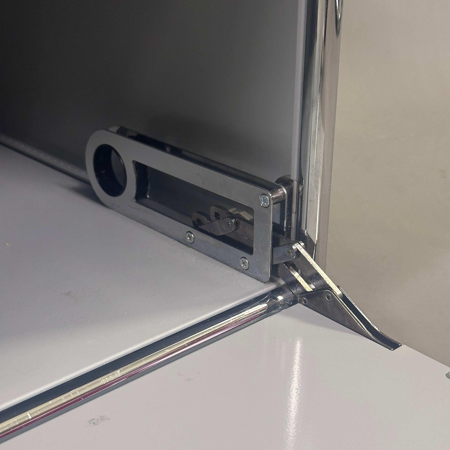 USM Haller Sideboard Detailansicht der grauen Klappe mit Schlossmechanismus und Chromrahmen