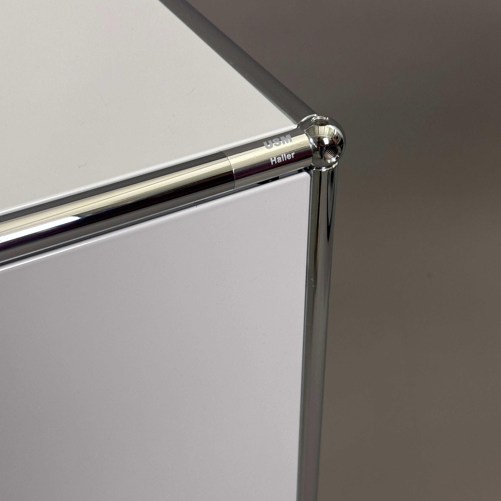 USM Haller Sideboard 1x2 lichtgrau mit chromfarbenem Metallrahmen und minimalistischer Oberfläche