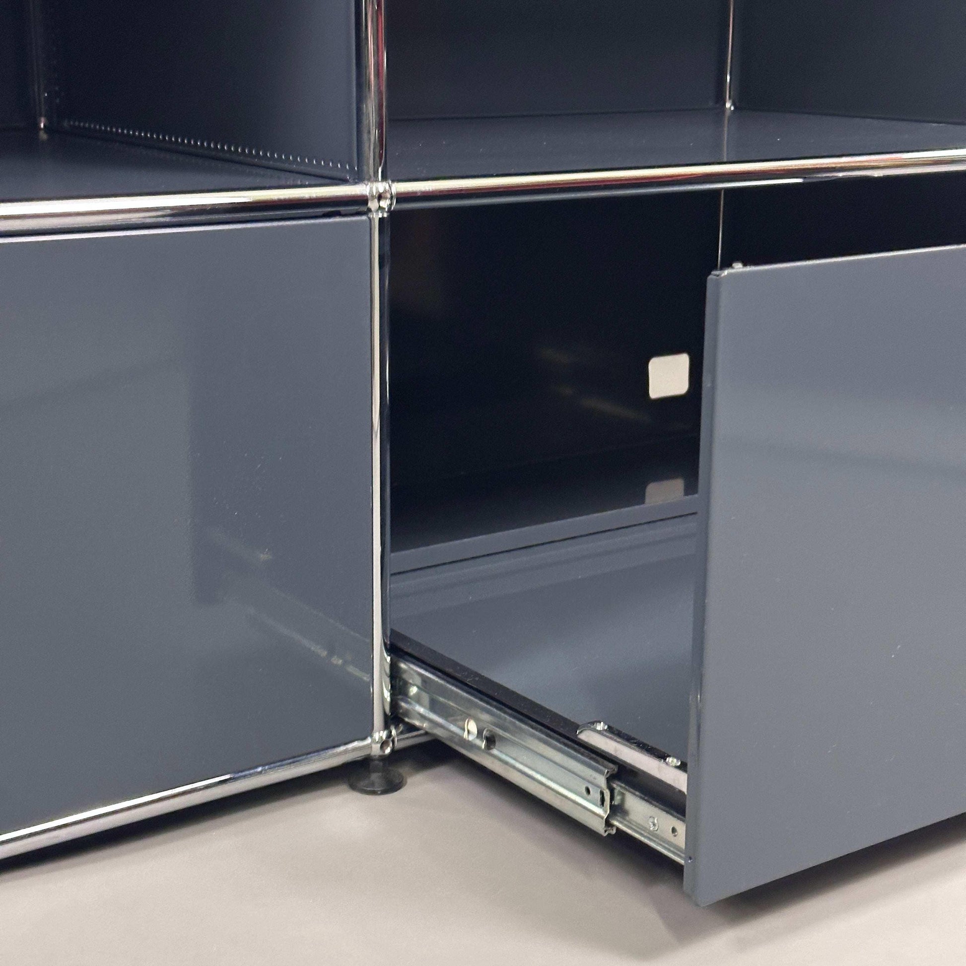 USM Haller Sideboard 2x2 anthrazit mit geöffnetem Schrankfach und Metallbeschlägen, 153x74x53 cm